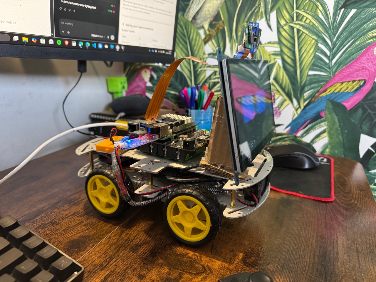 Left-side view of Bob AI rover showing its Raspberry Pi, wheeled chassis, camera, and display assembly