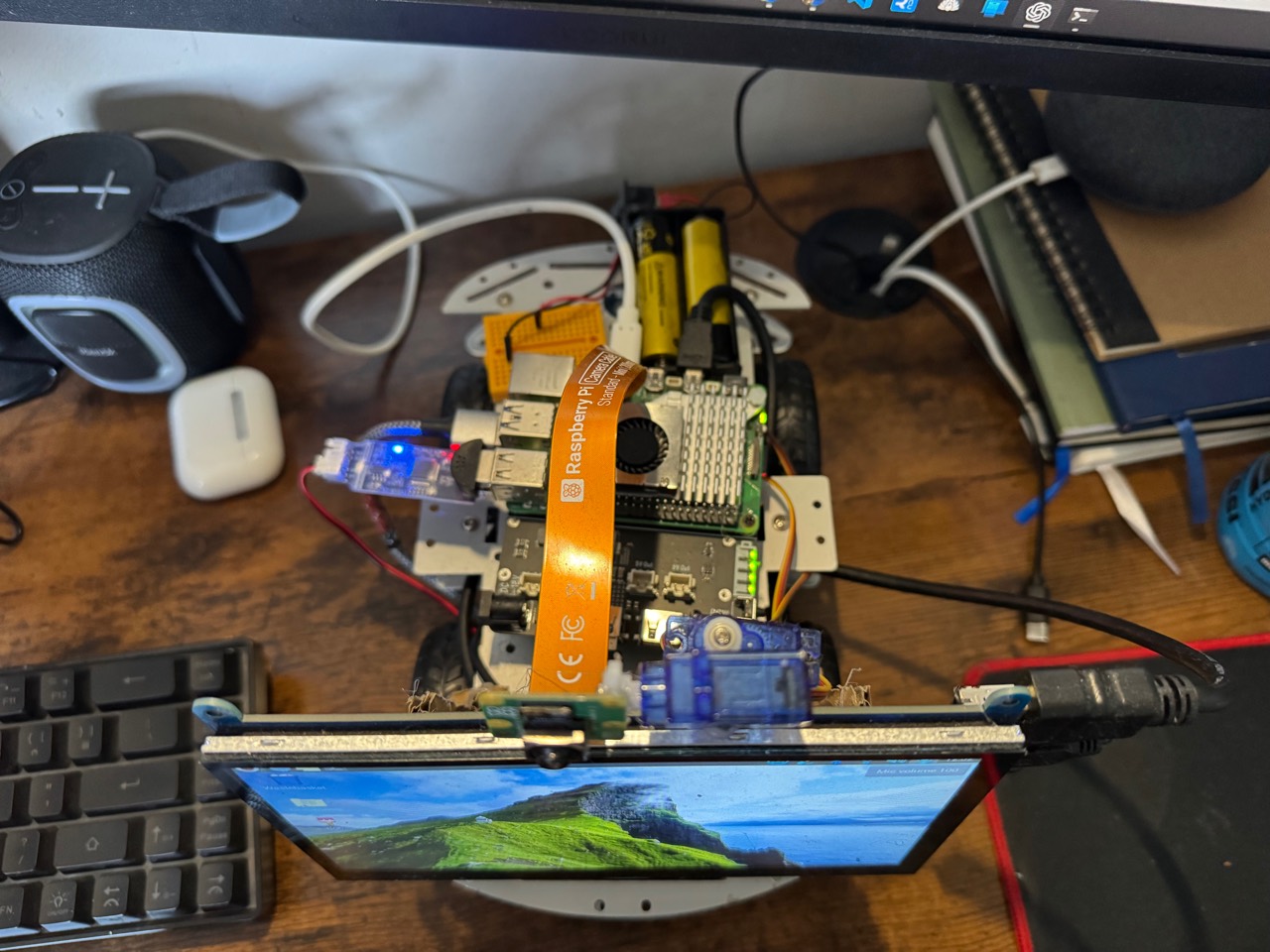 Top-down view of Bob AI rover showing the Raspberry Pi, camera ribbon cable, servos, battery pack, and display
